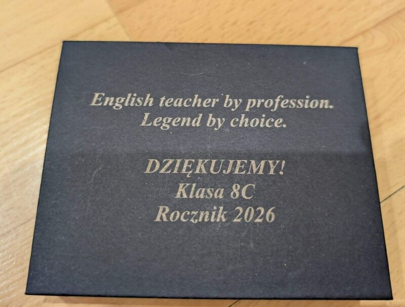 Granatowe pudełko z napisem „English teacher by profession. Legend by choice. Dziękujemy! Klasa 8C, rocznik 2026”
